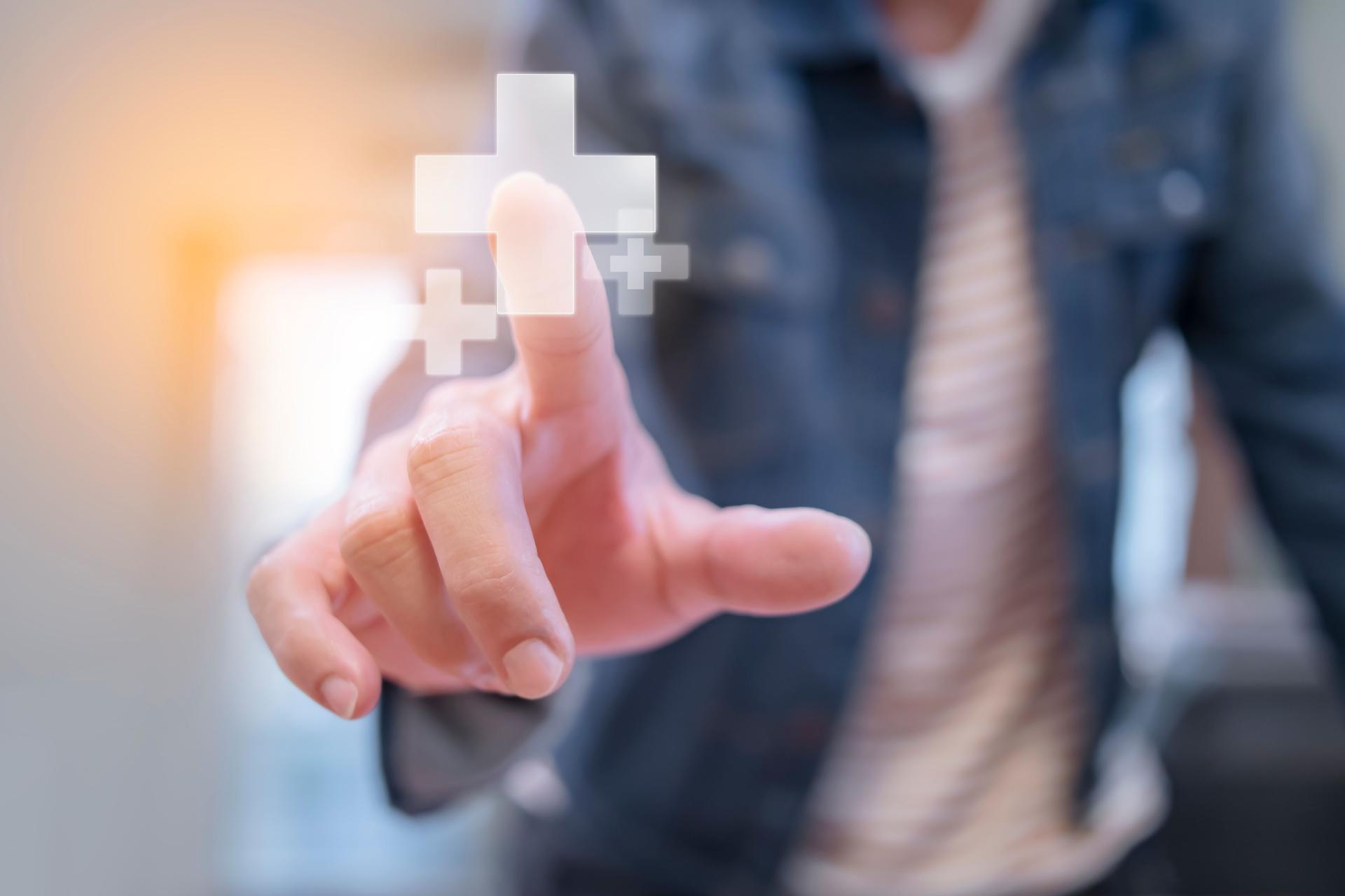 Human hand touching plus sign symbol