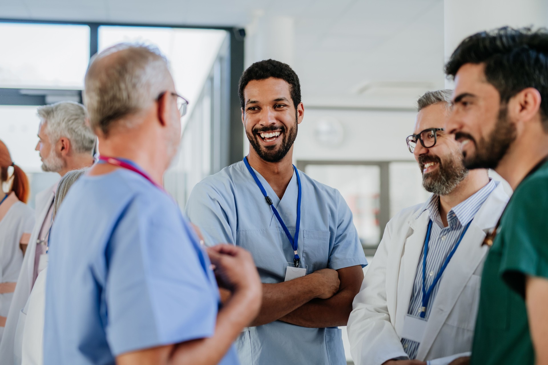 Team of doctors discussing something at hospital corridor.