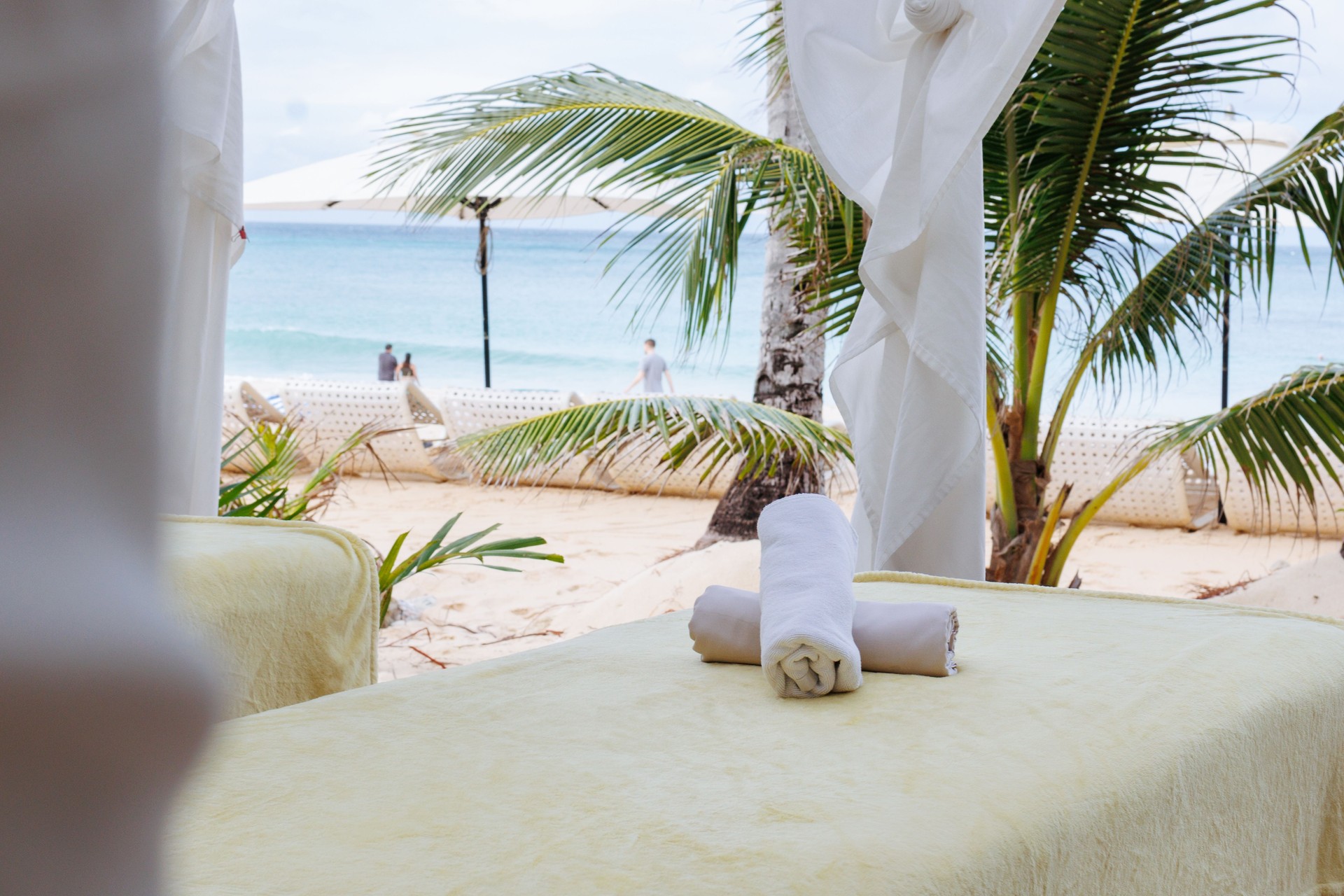 A tranquil beachfront massage setup features two massage tables under a canopy in Boracay
