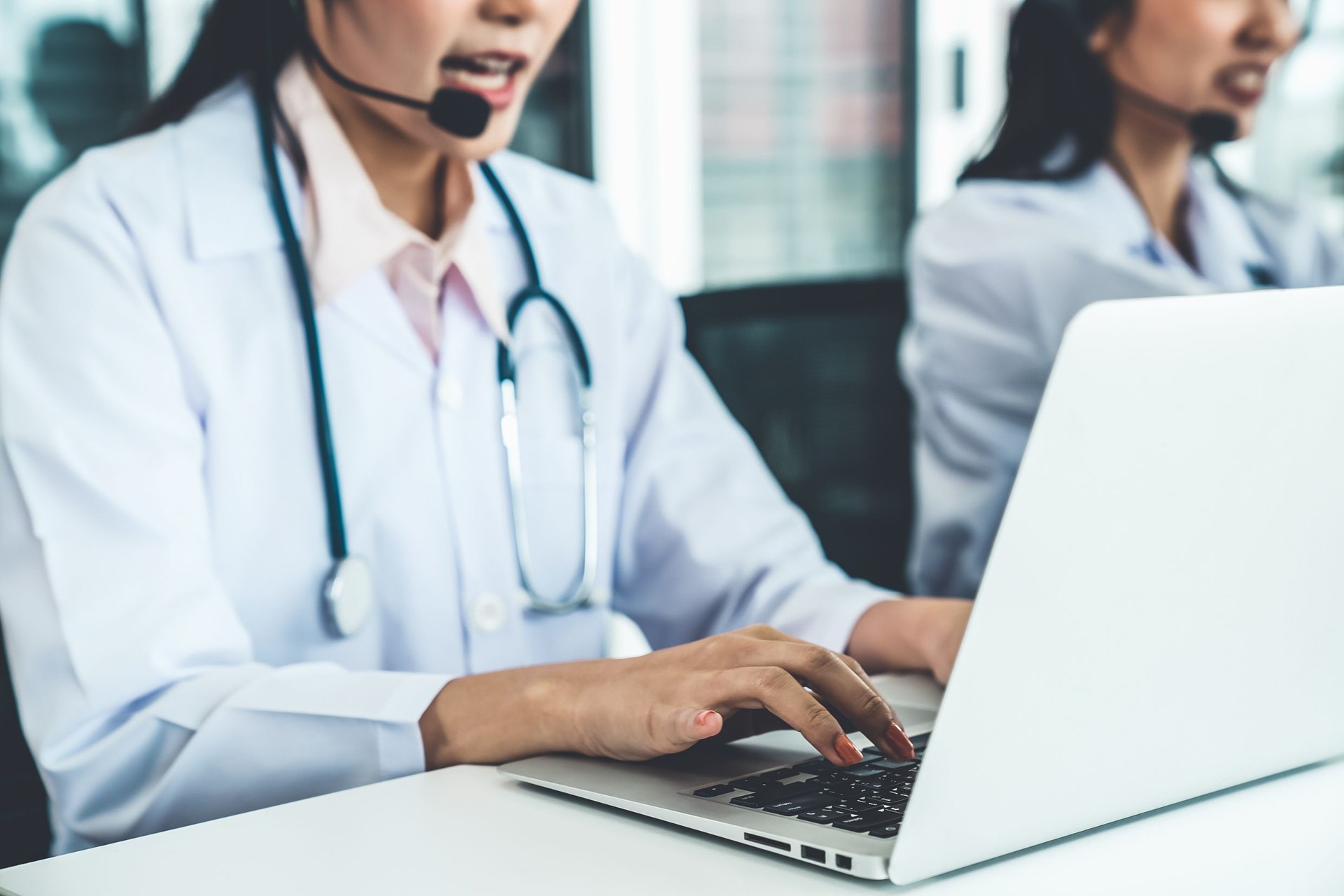 Doctor wearing headset talking actively on video call in hospital or clinic . Concept of telehealth and telemedicine service .